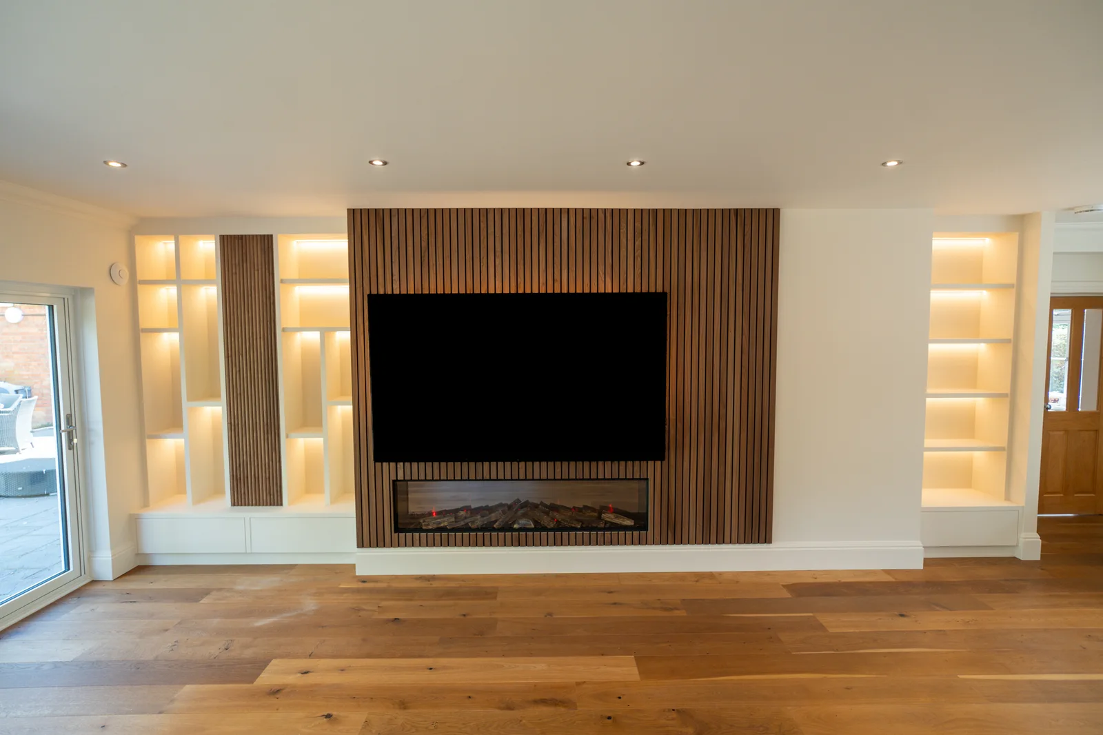 Timber slat media wall with integrated fireplace and illuminated shelving